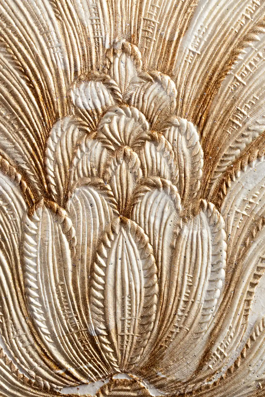 Extreme close-up of heavily embossed gold acanthus leaf texture with shimmer finish on wallpaper surface
