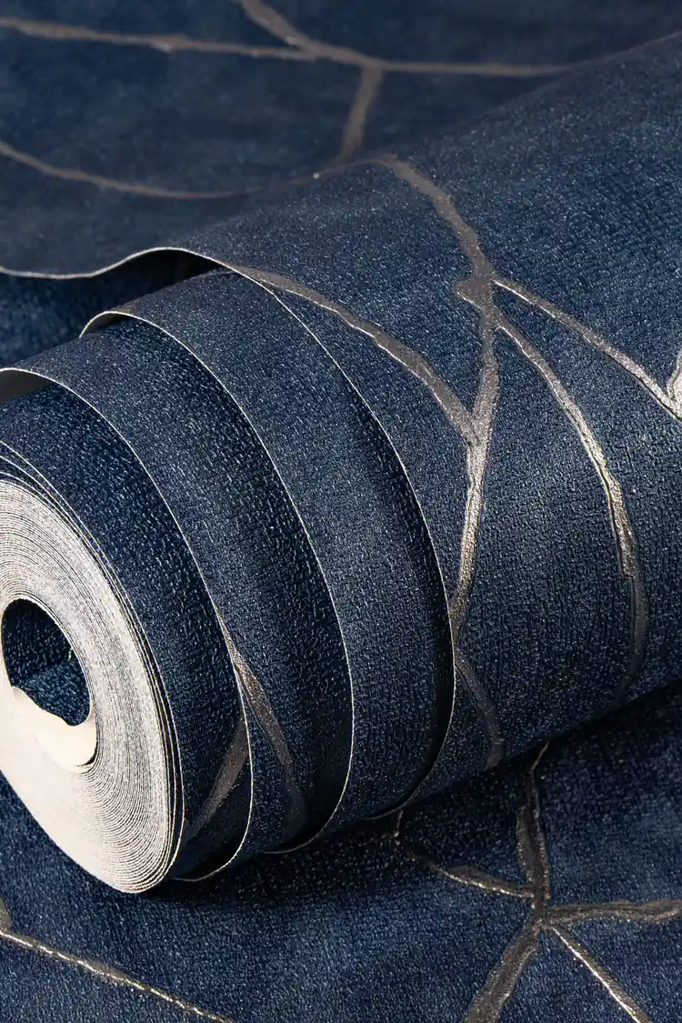 Room scene with navy abstract wallpaper installed behind mauve sofa, copper pendant lamp, and tropical green plant