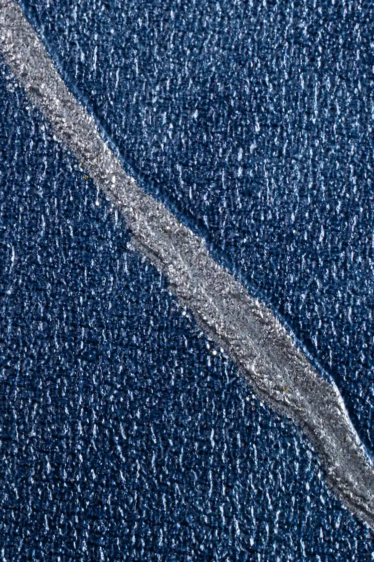 Extreme macro detail of silver metallic line accent on dark navy textured wallpaper surface