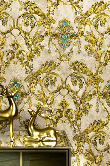 Installed gold baroque wallpaper with turquoise accents behind gold deer figurine on mirrored console