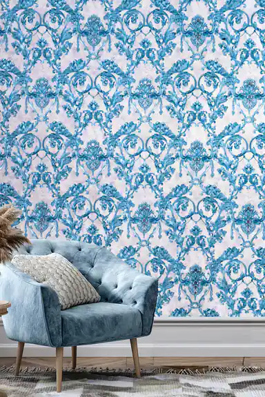 Living room with teal blue baroque wallpaper behind a velvet blue armchair and textured cushions