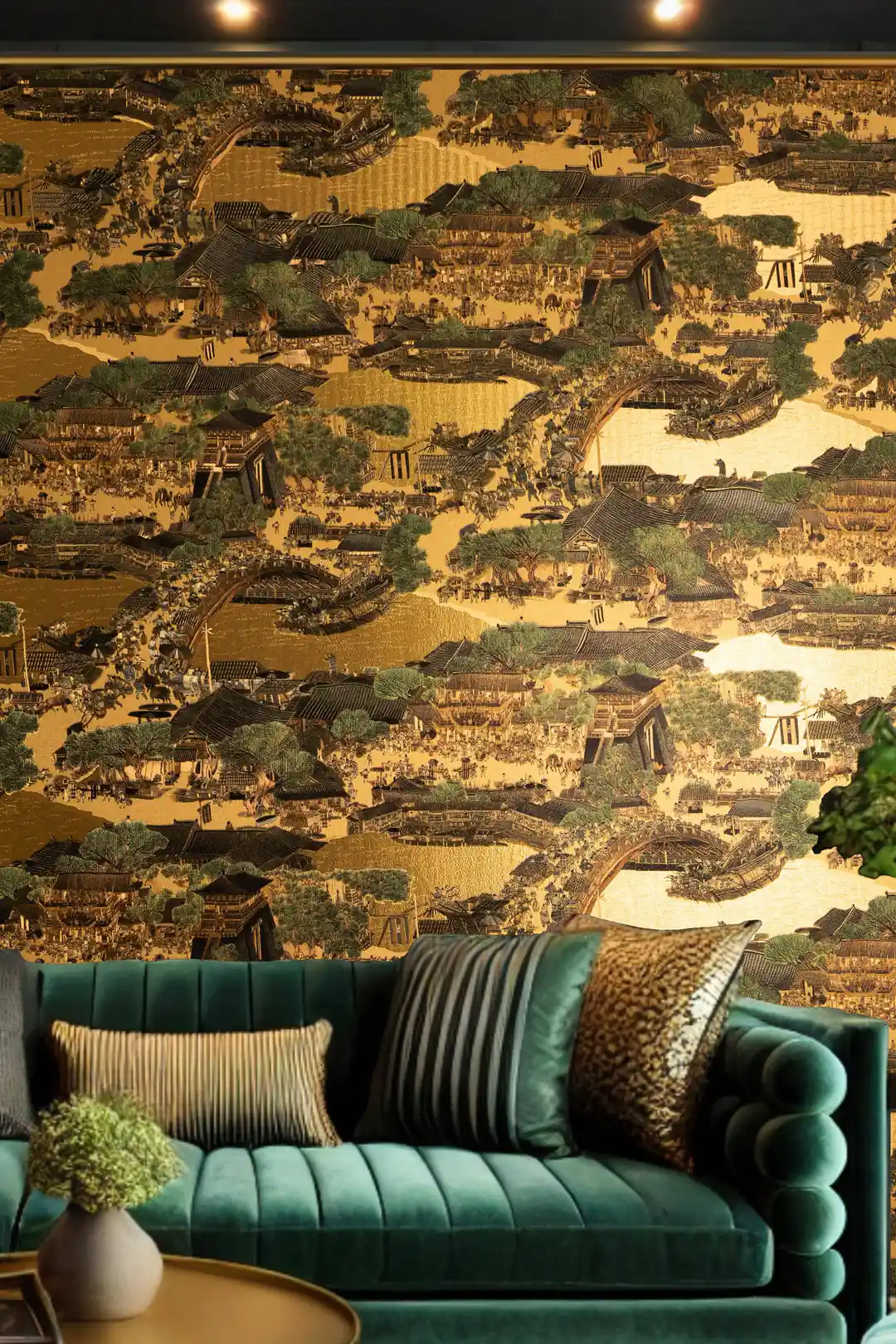 Luxurious living room with golden village mural wallpaper behind emerald green velvet sofa and accent pillows