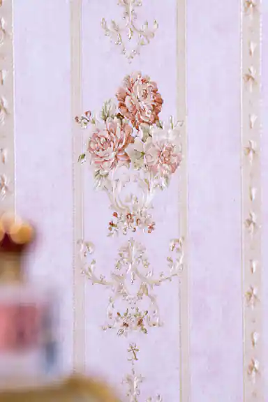 Close-up of embossed pink rose bouquet with ornate scroll detail between vertical stripes on wallpaper