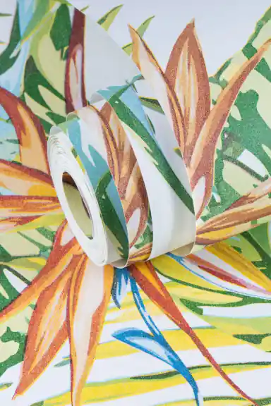 Partially unrolled tropical wallpaper roll showing colourful palm leaves and bird of paradise