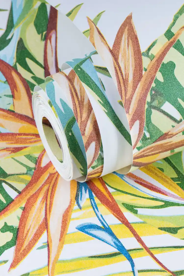Partially unrolled tropical wallpaper roll showing colourful palm leaves and bird of paradise
