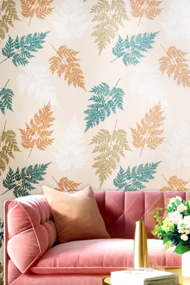 Living room with beige fern leaves wallpaper showing teal, orange, and white frond pattern behind pink sofa