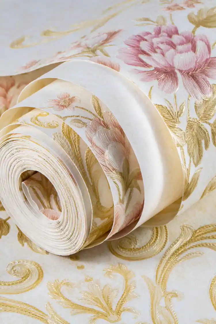 Rolled cream floral damask wallpaper showing pink rose and gold scroll motif on warm ivory background
