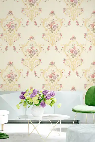 Living room with cream floral damask wallpaper behind green velvet chair, white sofa, and purple flower arrangement