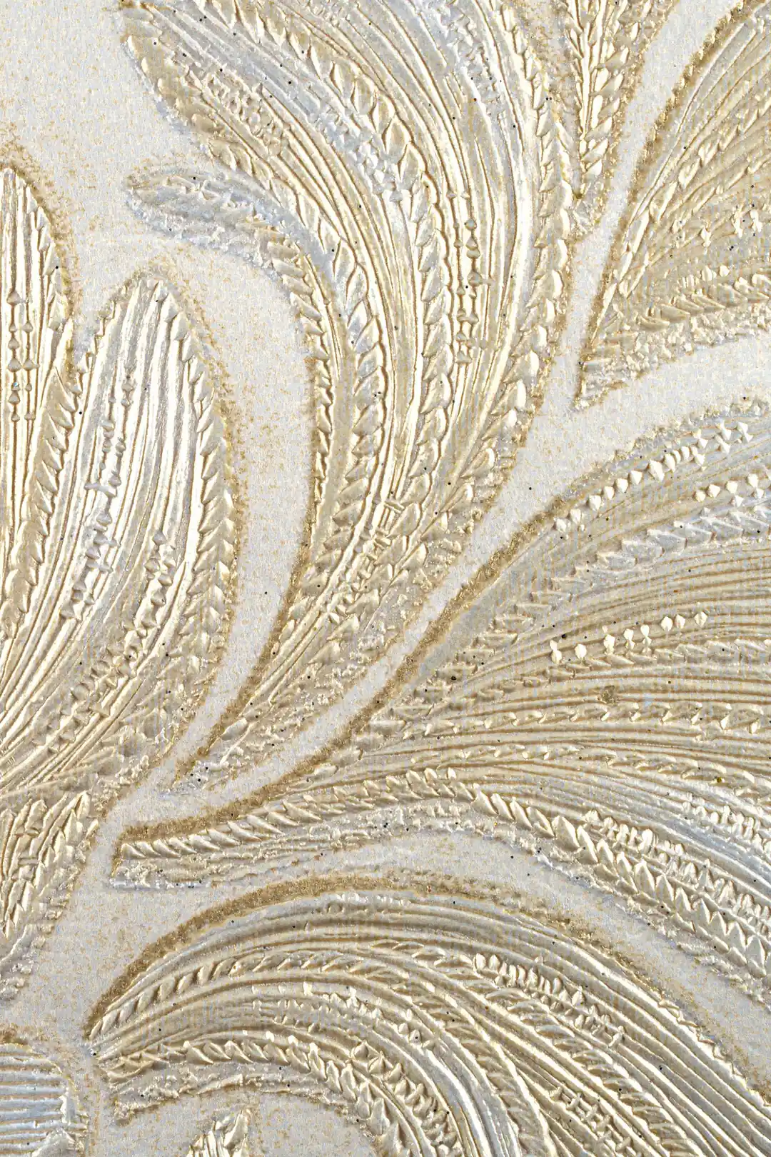 Extreme macro of embossed cream and gold feathered scroll texture showing fine braided ridge detail