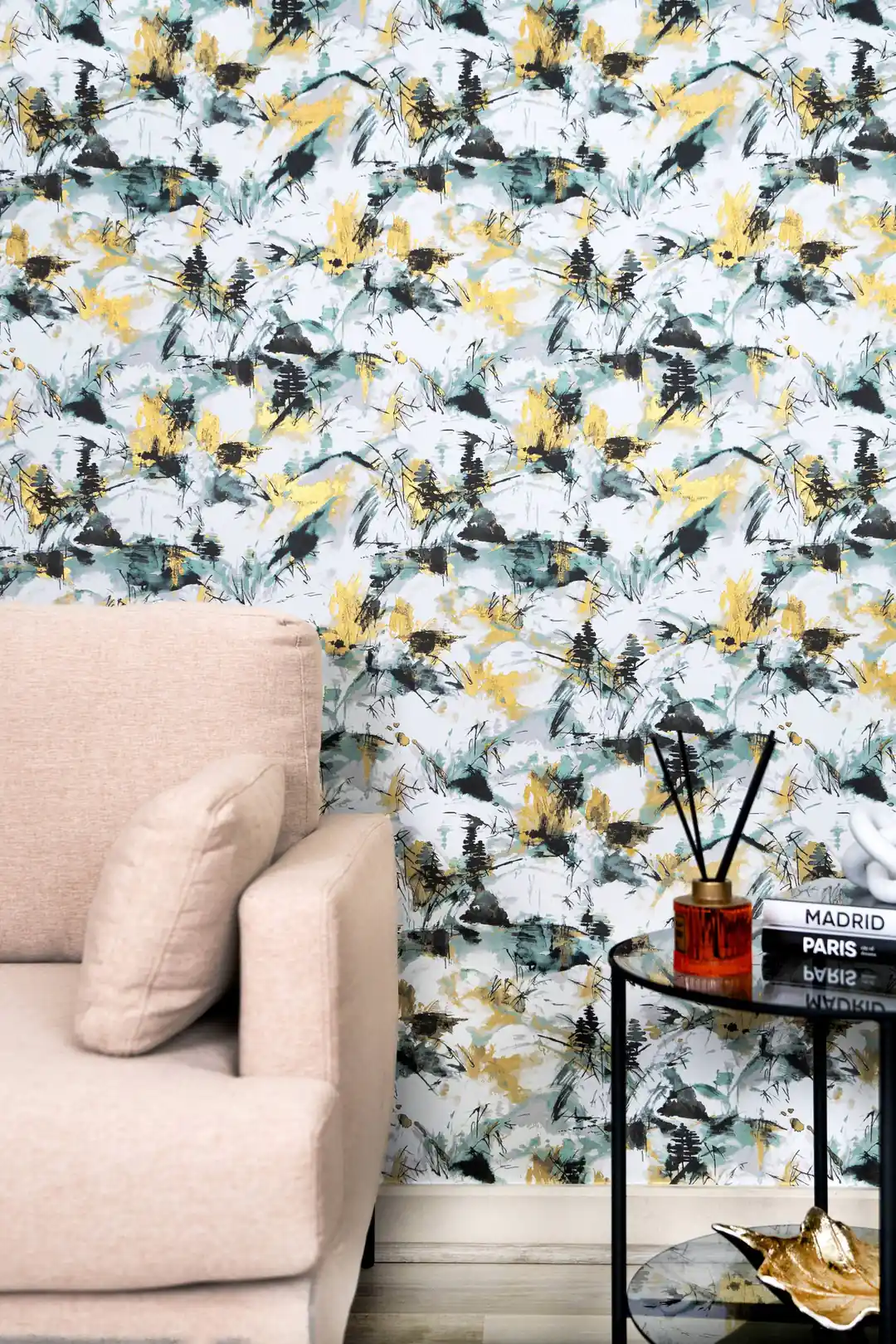 Living room with abstract ink-splash wallpaper in teal, black, and gold behind a pink armchair and side table