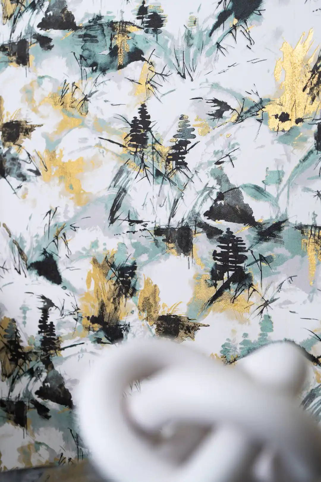 Close-up of abstract mountain wallpaper showing teal ink washes, dark pine silhouettes, and gold detail