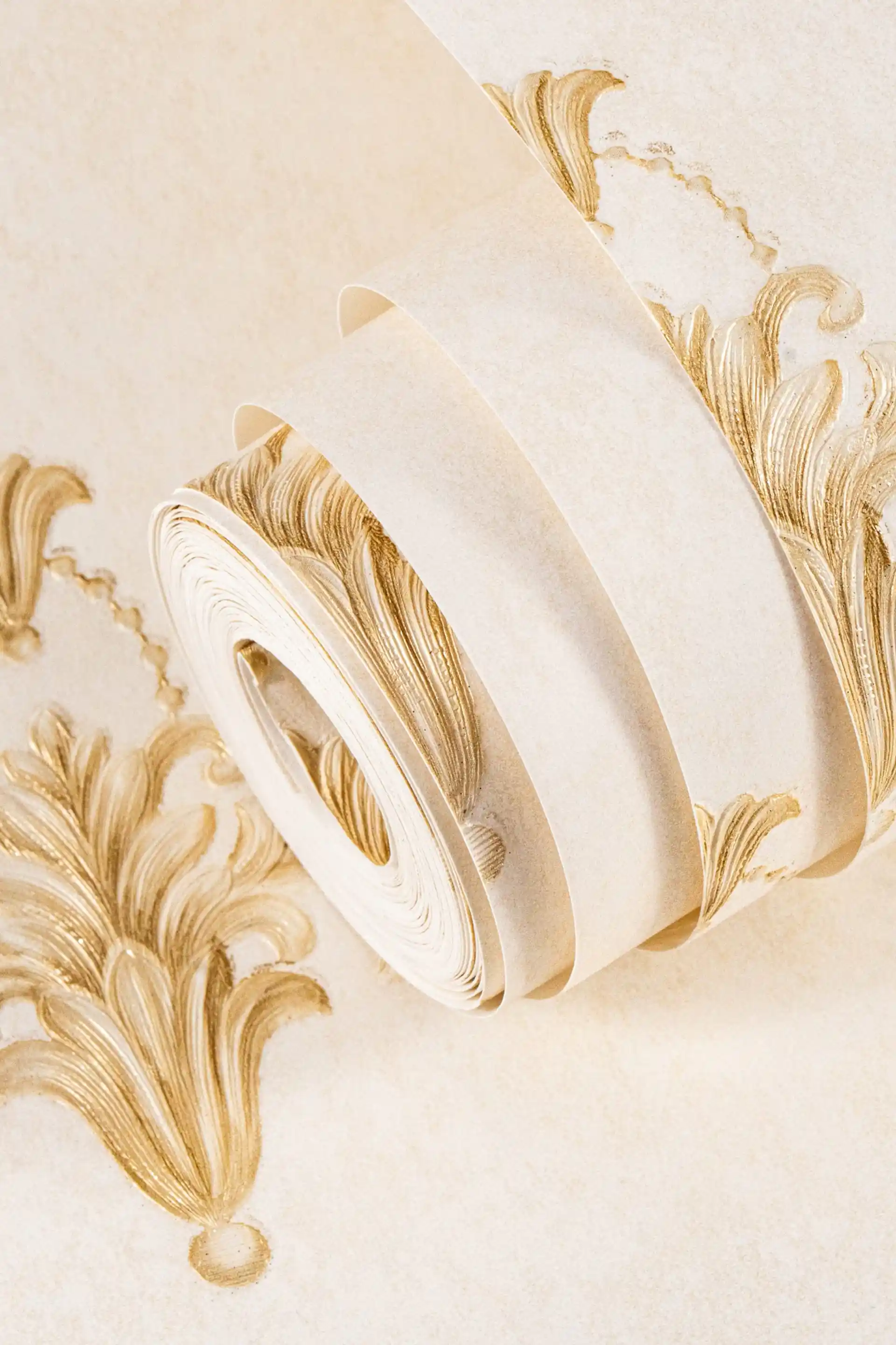 Installed golden fleur motif wallpaper with small baroque emblems on cream background beside table lamp