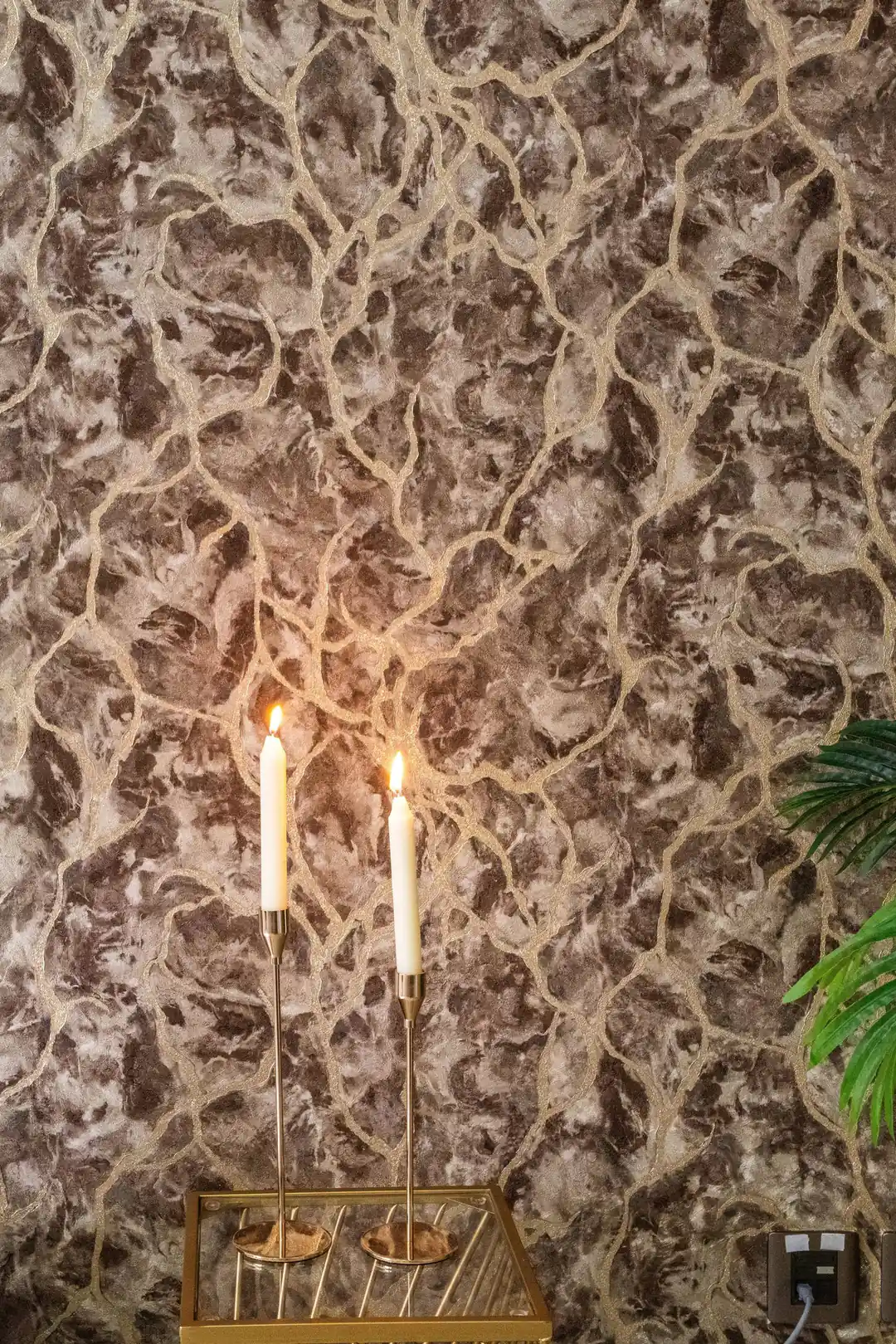 Brown marble effect wallpaper installed on accent wall with candle holders and greenery