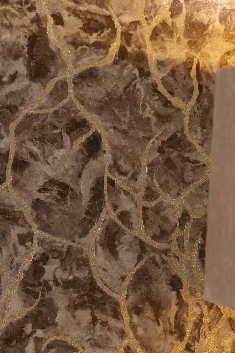 Close-up of brown marble wallpaper showing gold glitter veins and aged stone texture detail