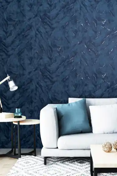 Midnight blue marble effect wallpaper installed in modern living room with grey sofa and teal cushions
