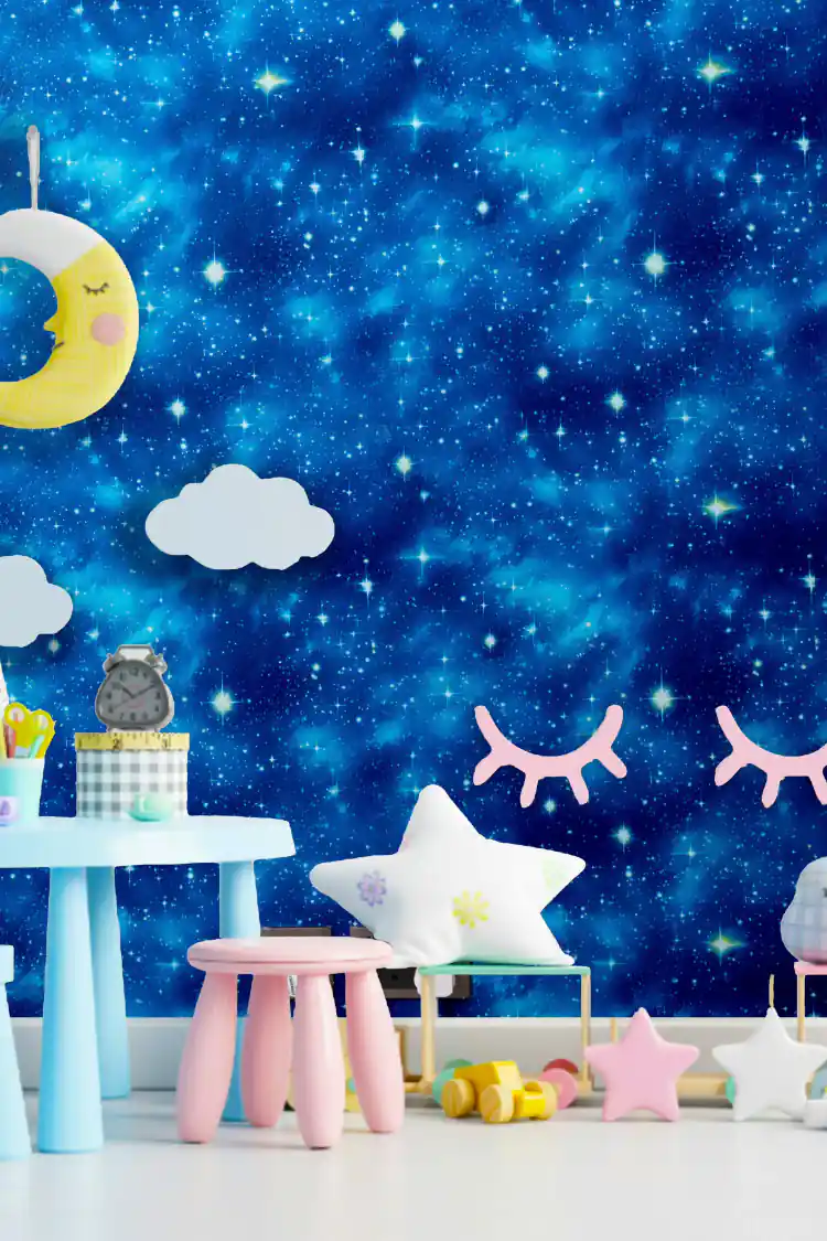 Starry blue galaxy wallpaper installed in children's room with moon decor, star pillows and pastel furniture