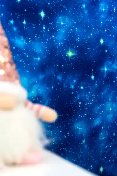 Close-up of starry blue galaxy wallpaper with bright glowing star effects and a decorative figurine in the foreground