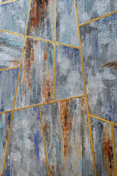 Close-up of abstract geometric wallpaper showing brush stroke texture in blue, grey and rust tones