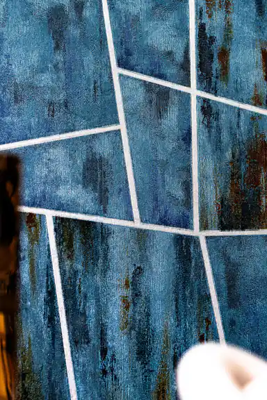 Close-up view of teal geometric panels wallpaper with abstract brush stroke detail