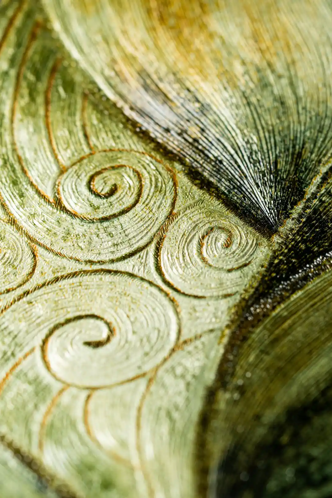 Extreme macro of embossed wallpaper showing raised gold and teal leaf texture with fine ridges