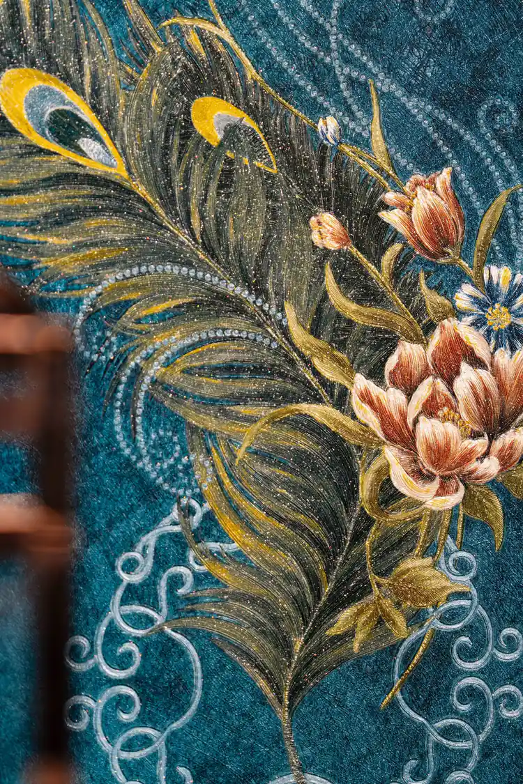 Close-up of embossed peacock feather with tulip flowers and glitter highlights on teal background