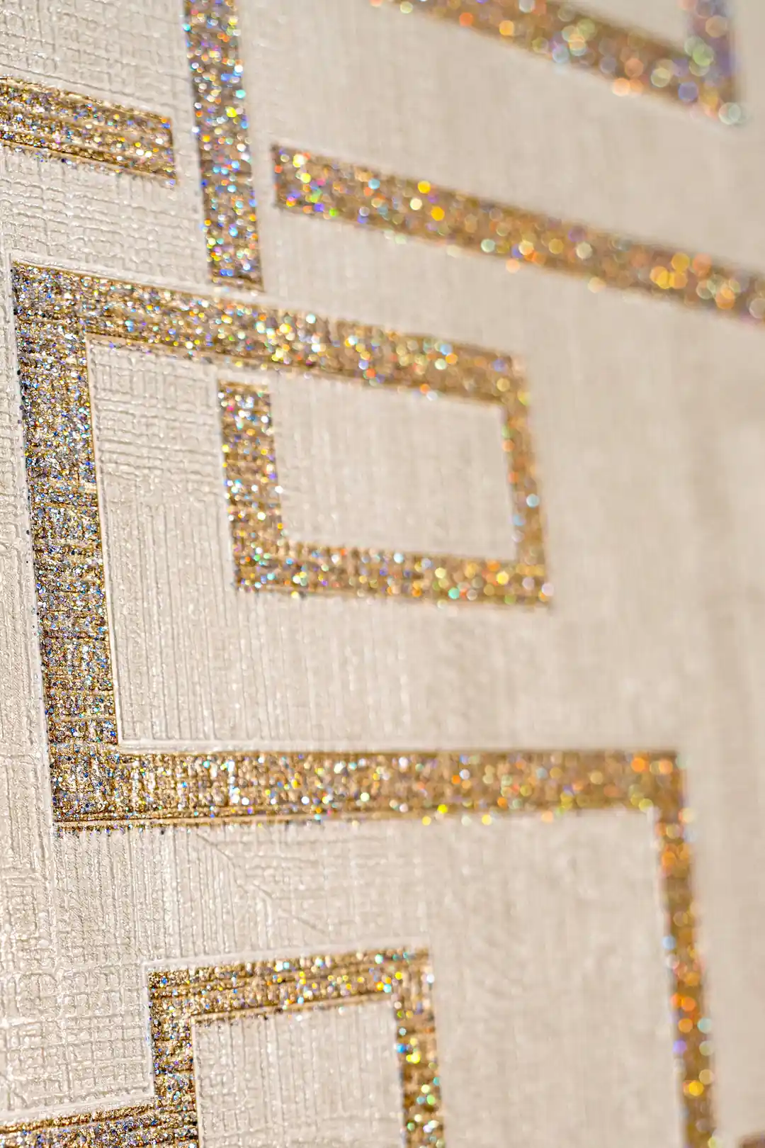 Close-up of holographic gold glitter maze pattern showing sparkling interlocking square details