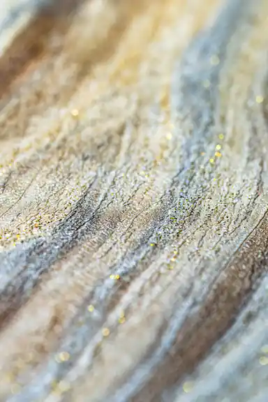 Extreme macro of marble wave wallpaper showing gold and silver glitter particles in wave texture