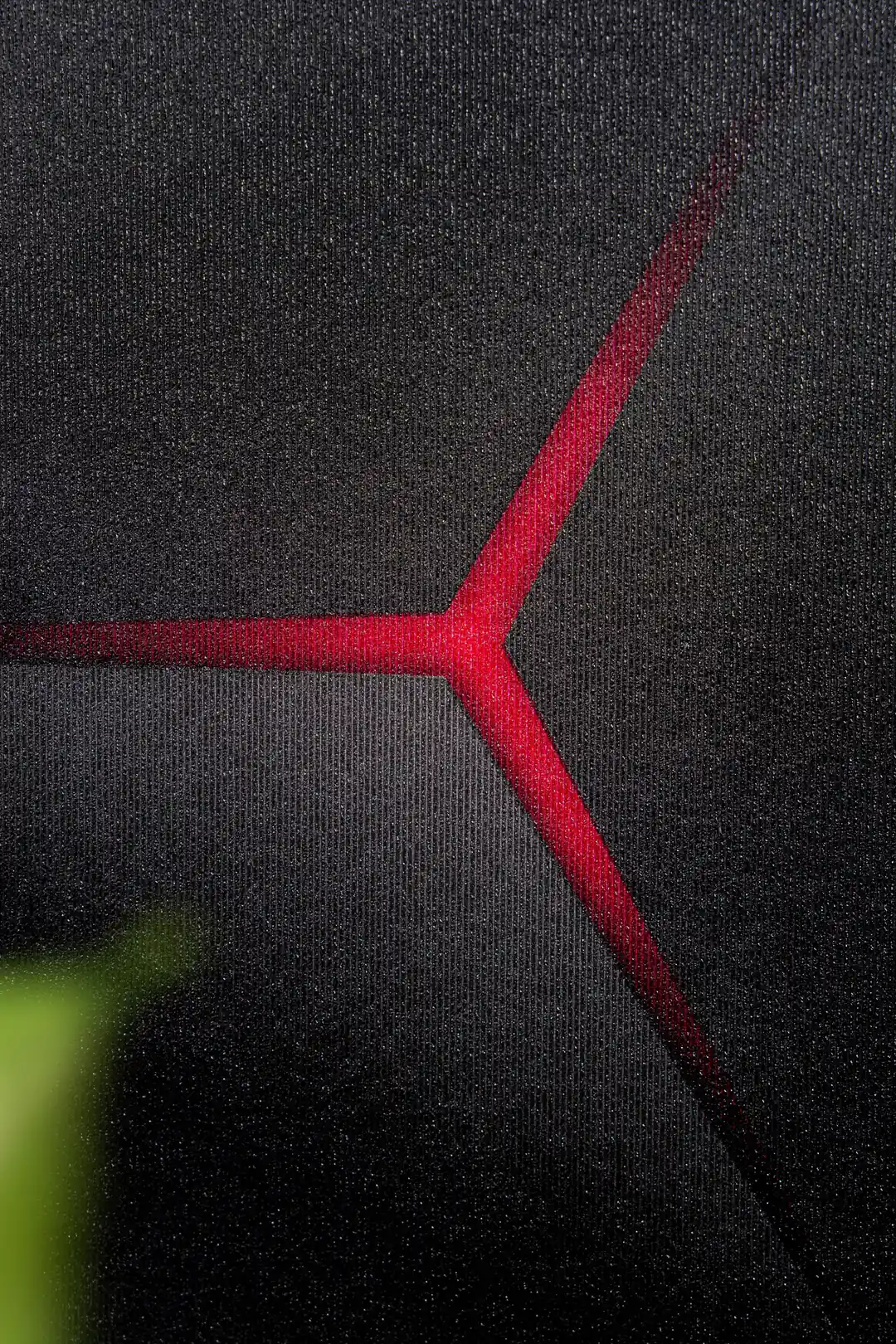 Macro detail of red glowing junction lines on the dark textured hexagon wallpaper surface