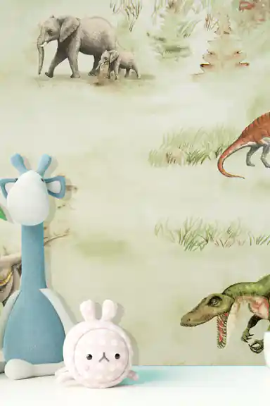 Close-up room scene showing dinosaur and elephant illustrations with plush toys against the green wallpaper