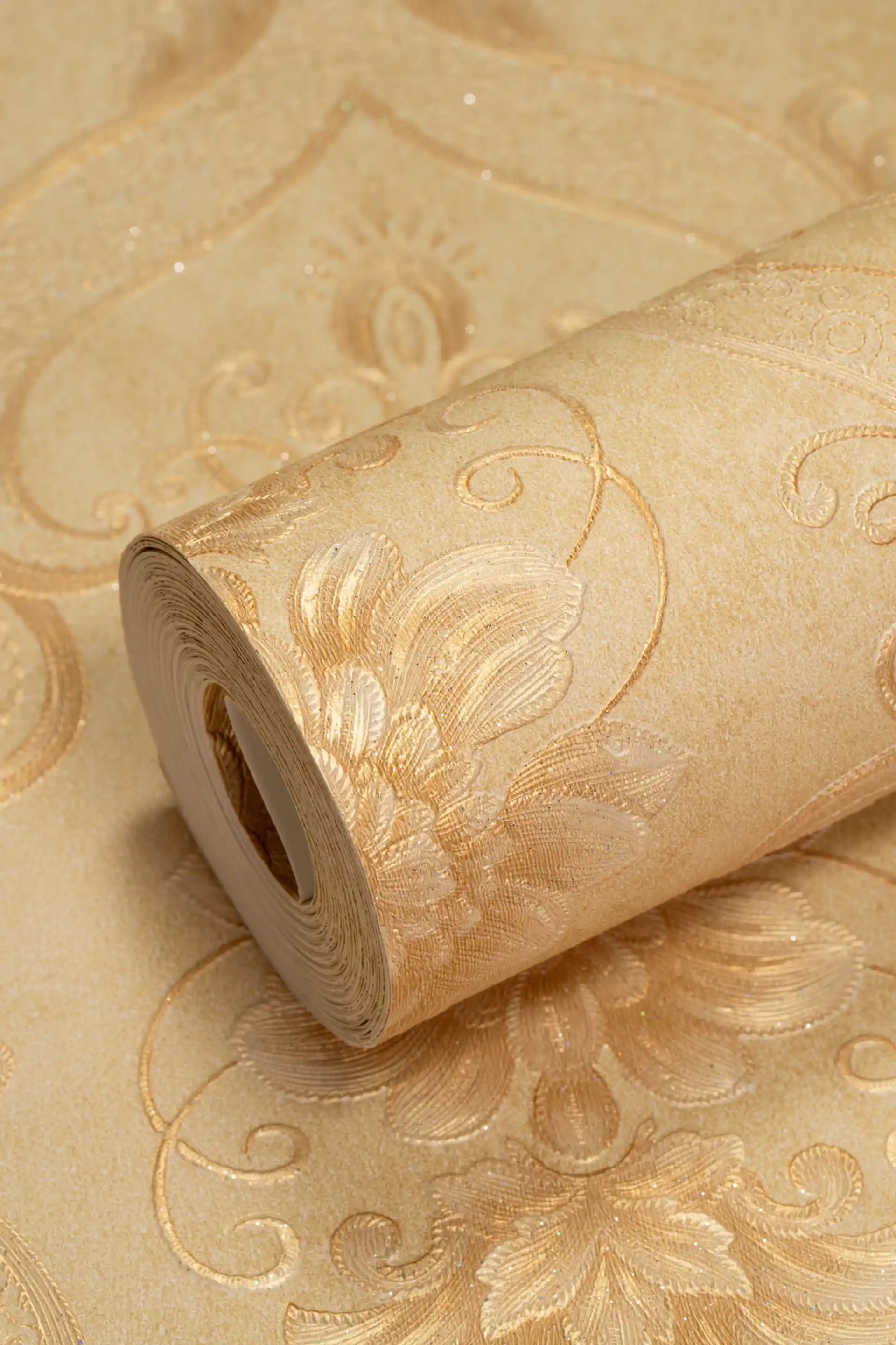 Embossed beige baroque damask wallpaper roll with golden floral scroll pattern and glitter finish