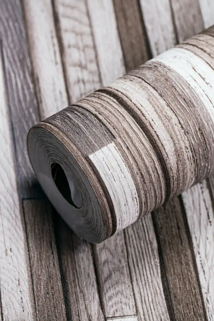 Weathered multicolor wood plank wallpaper roll showing rustic brown, grey, and white distressed plank pattern