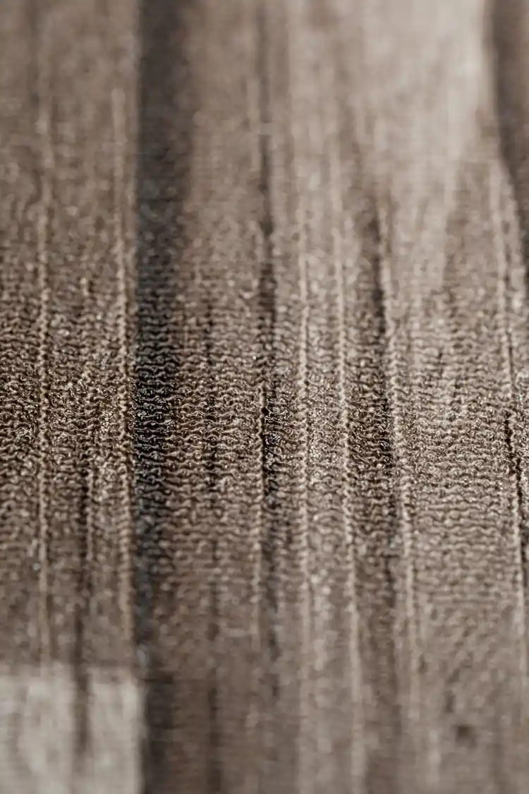 Macro texture detail showing the woven fabric surface of the weathered wood plank wallpaper