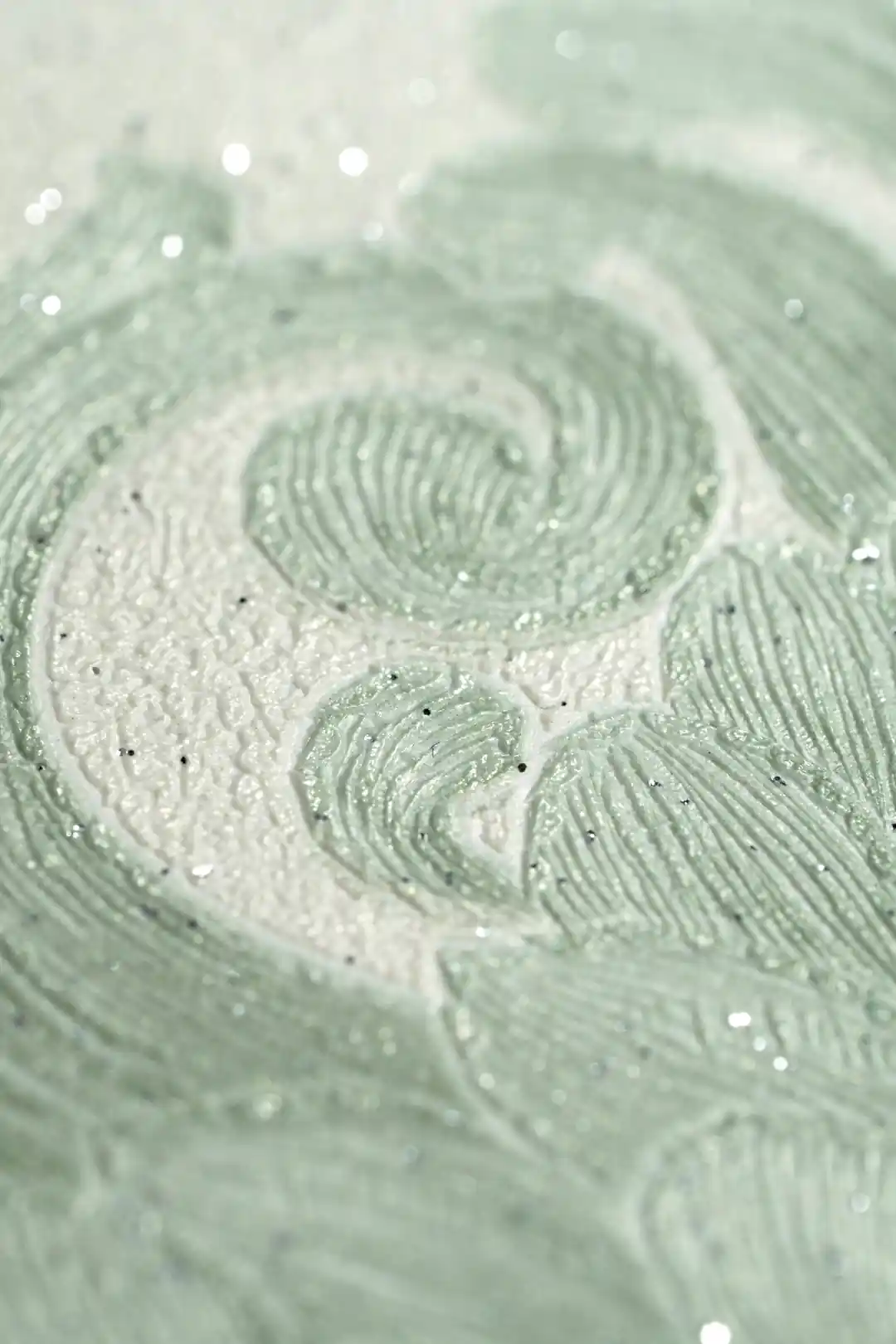 Extreme macro of the glittering embossed swirl pattern revealing sparkling texture on the green wallpaper