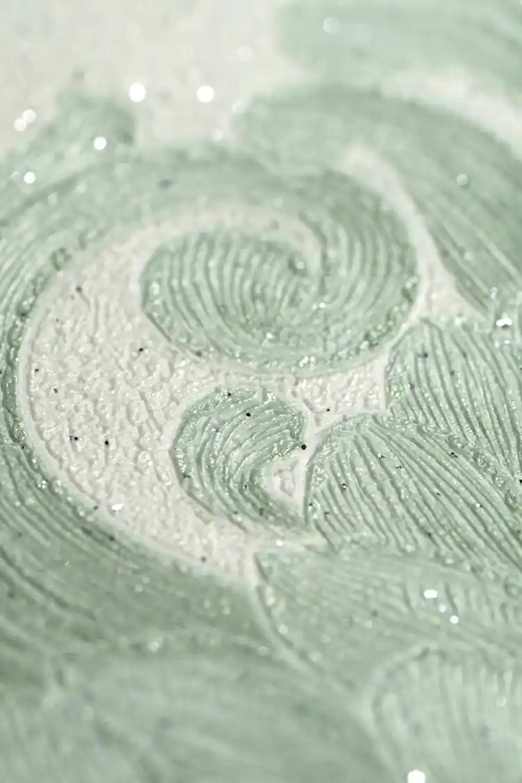 Extreme macro of the glittering embossed swirl pattern revealing sparkling texture on the green wallpaper