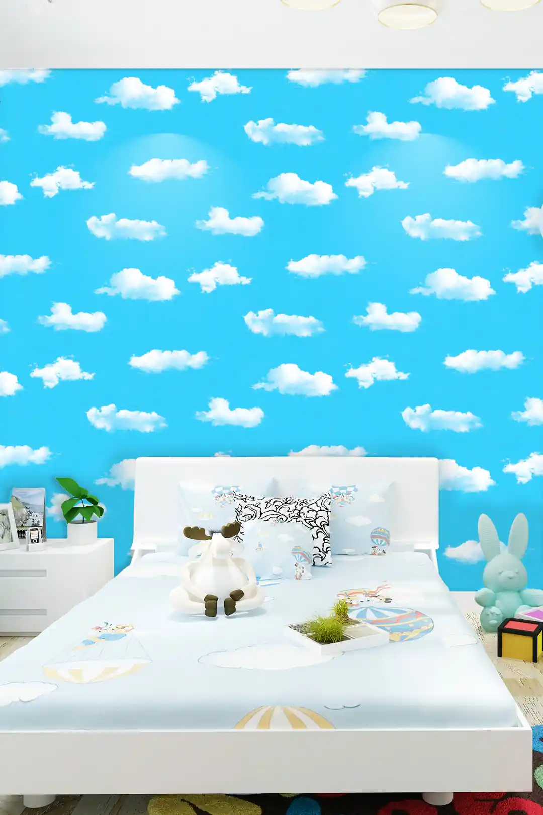 Children's bedroom with blue sky and cloud wallpaper behind a white bed with stuffed toys and decor