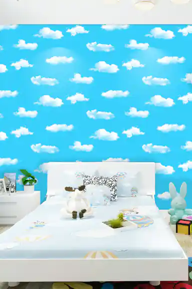 Children's bedroom with blue sky and cloud wallpaper behind a white bed with stuffed toys and decor