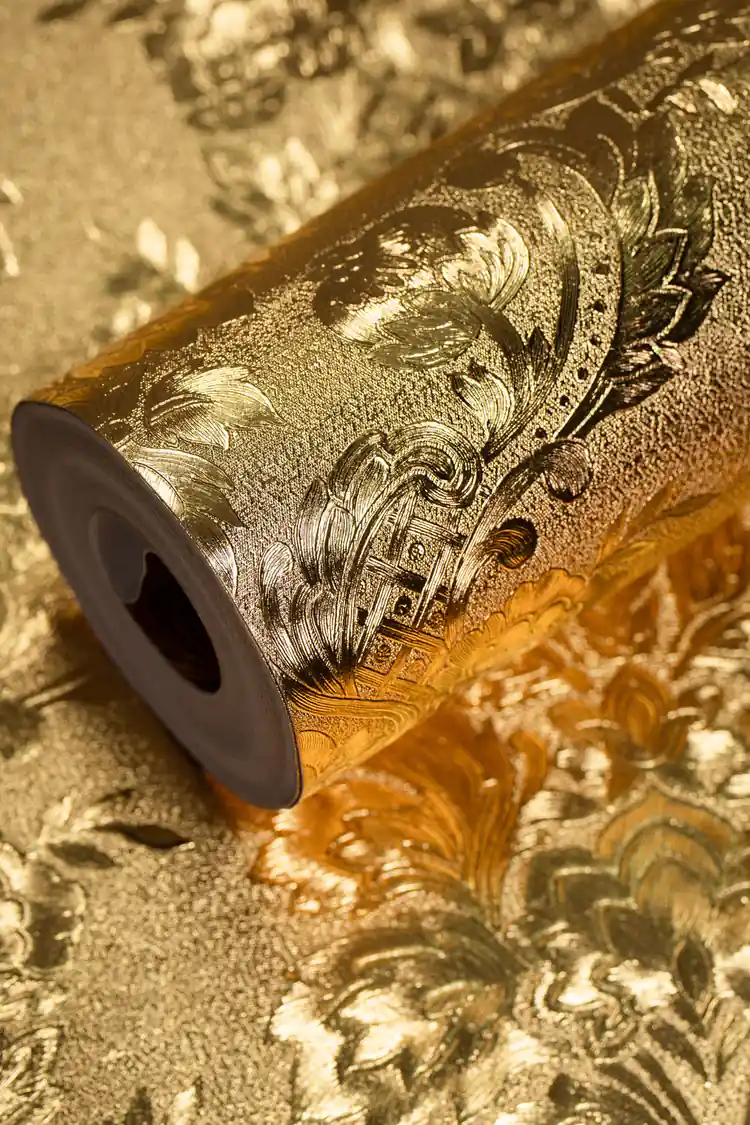 Elegant entryway with gold foil damask wallpaper behind a dark wood dresser and sunburst mirror