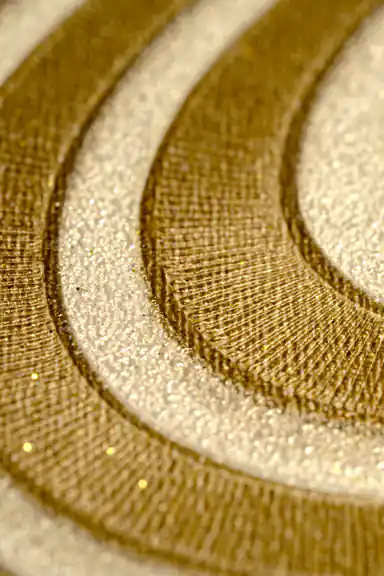 Extreme macro of the glitter-accented gold and cream wavy line texture showing surface depth