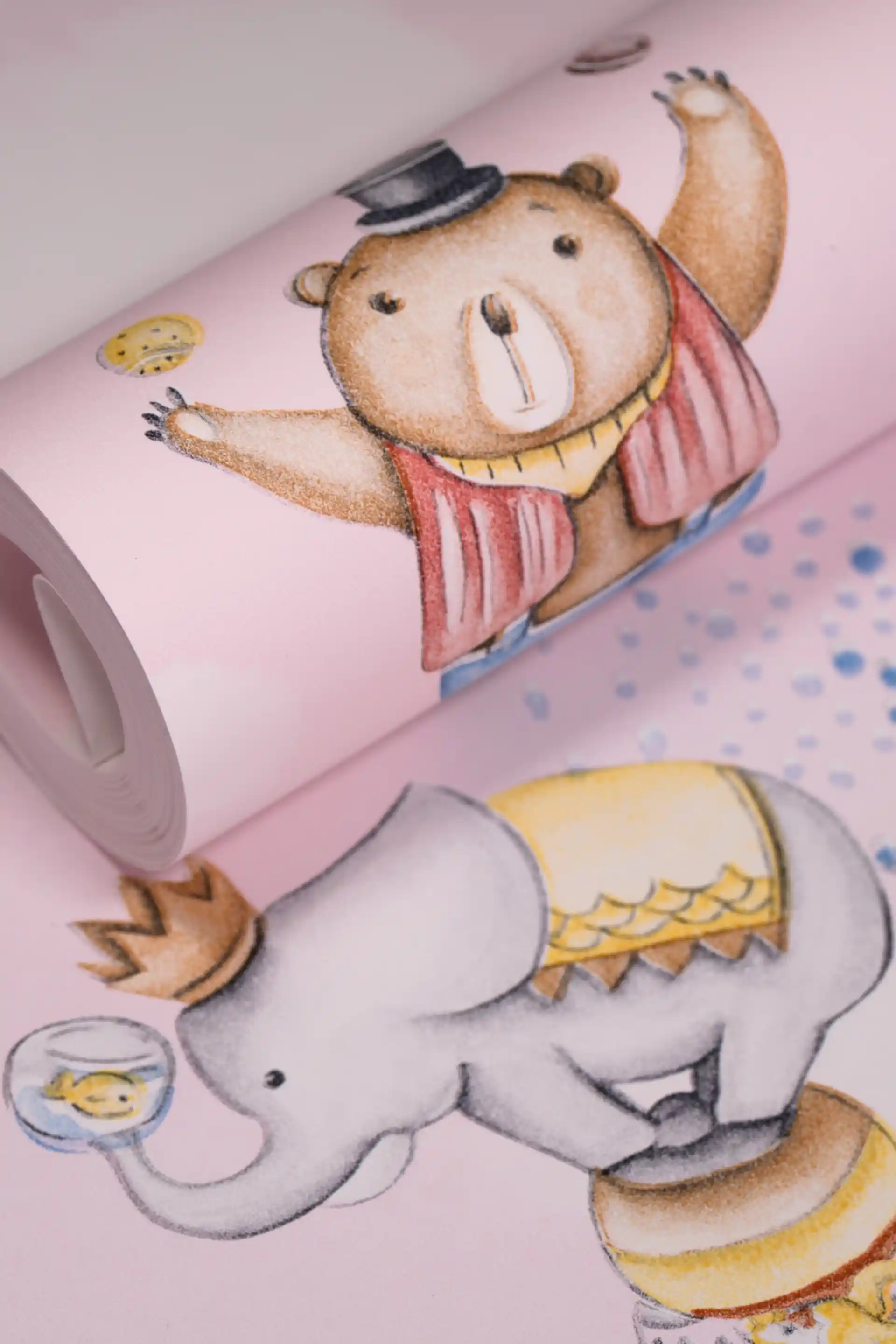Cute pink circus wallpaper roll with illustrated bear in top hat juggling and elephant holding a fishbowl on a soft pink base