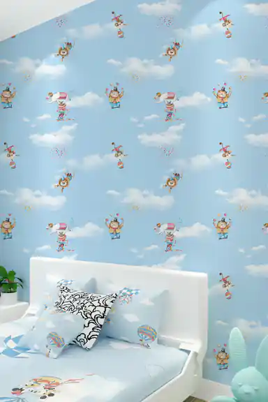 Boy's bedroom with blue circus wallpaper installed behind a white bed with patterned pillows and toys