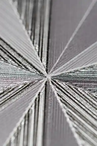 Extreme macro detail of the silver shimmer radiating lines at the center of the geometric fan pattern