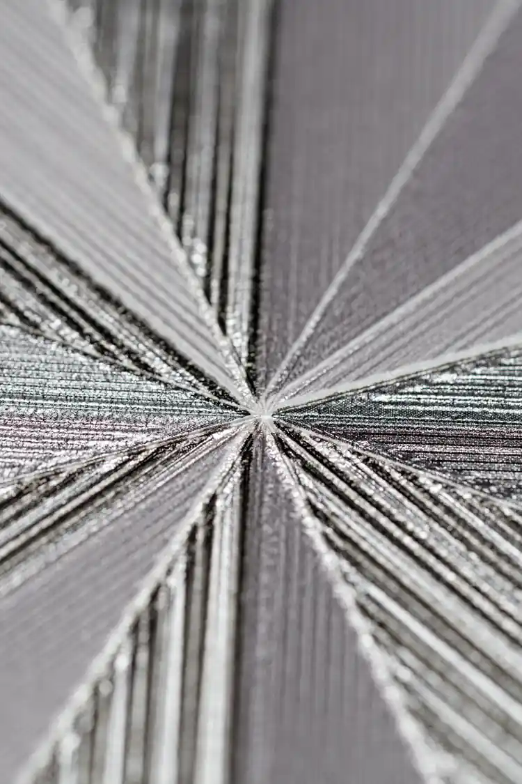 Extreme macro detail of the silver shimmer radiating lines at the center of the geometric fan pattern