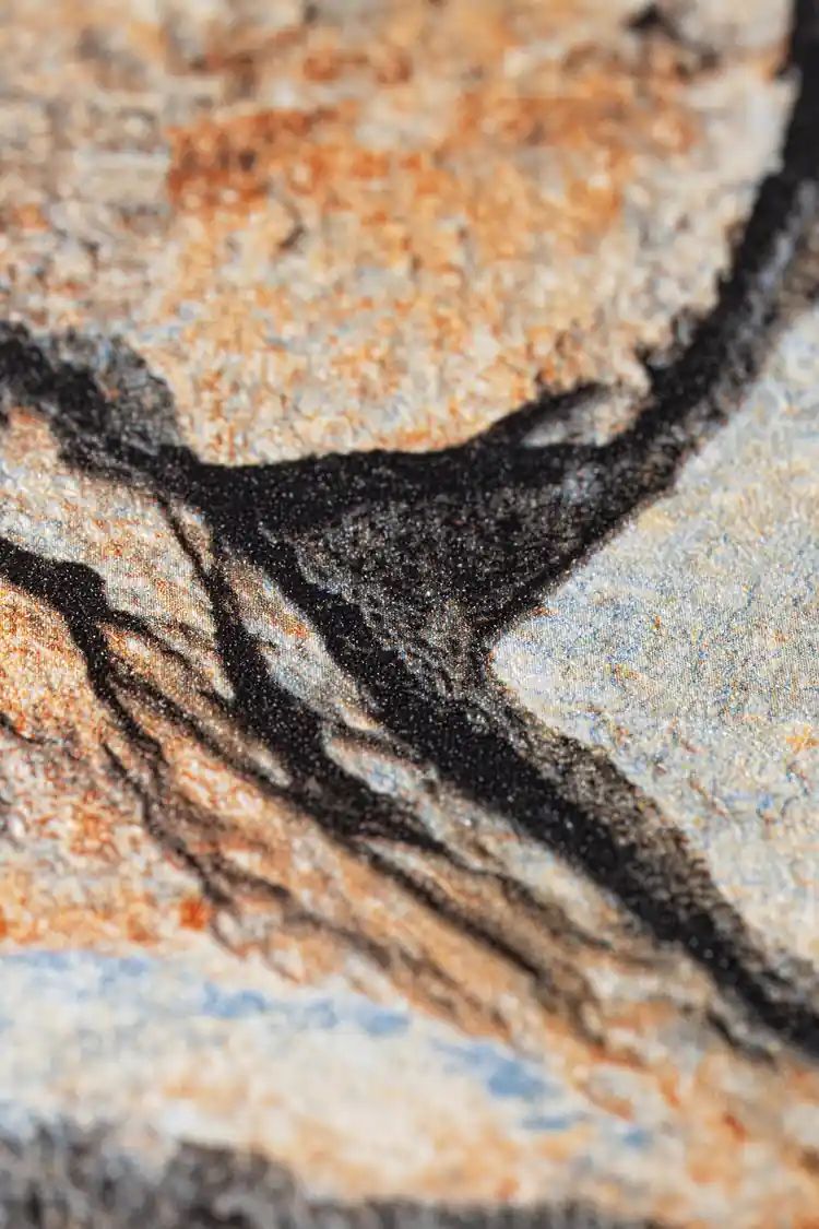 Extreme macro of the textured stone wallpaper showing printed crack detail between orange and grey rocks