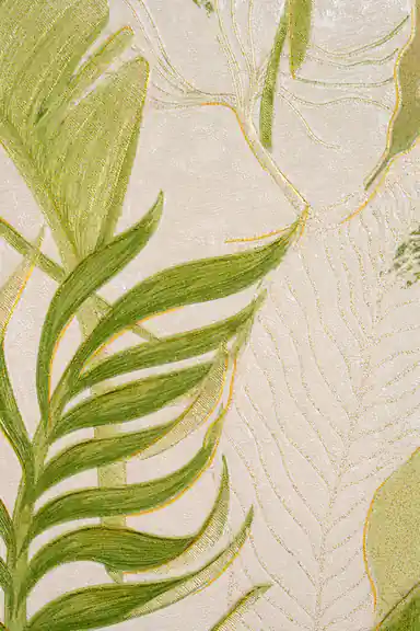 Flat lay detail of green palm fronds with gold-edged veins on an ivory textured wallpaper surface