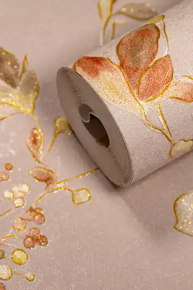 Wallpaper roll showing autumn watercolor leaves with gold glitter outlines on a soft peach pink background