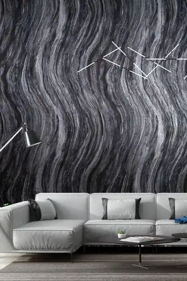 Modern living room with black and grey marble swirl wallpaper behind a white sectional sofa and chandelier