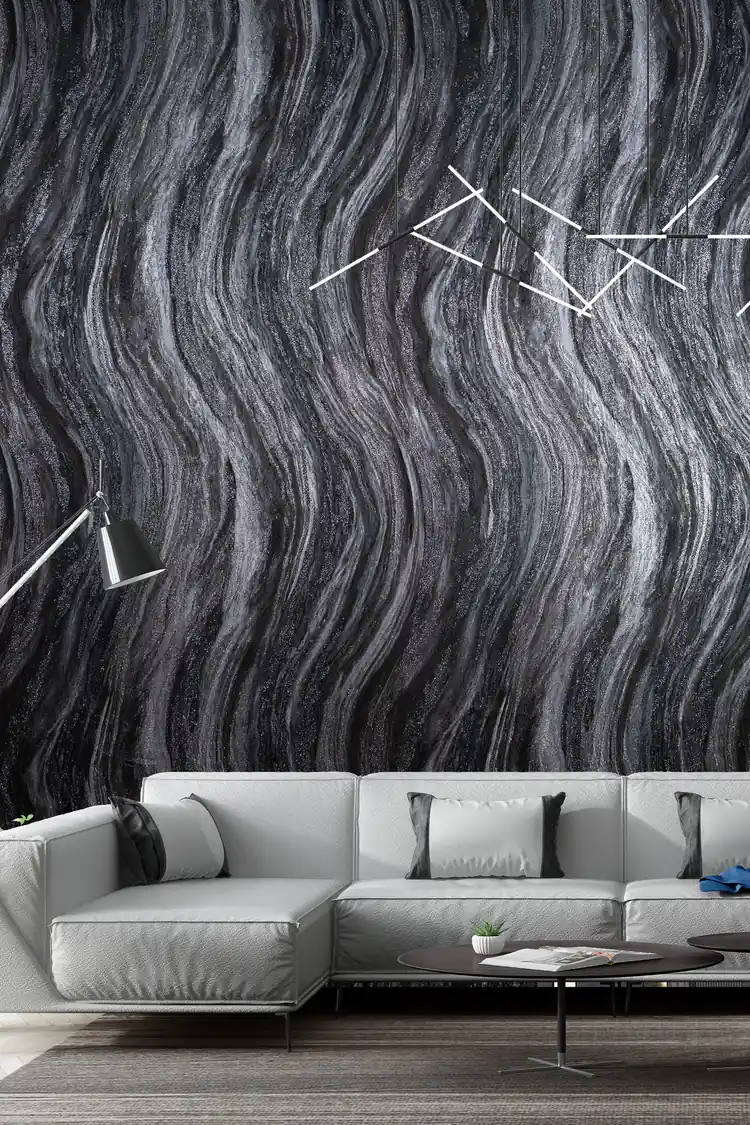 Modern living room with black and grey marble swirl wallpaper behind a white sectional sofa and chandelier