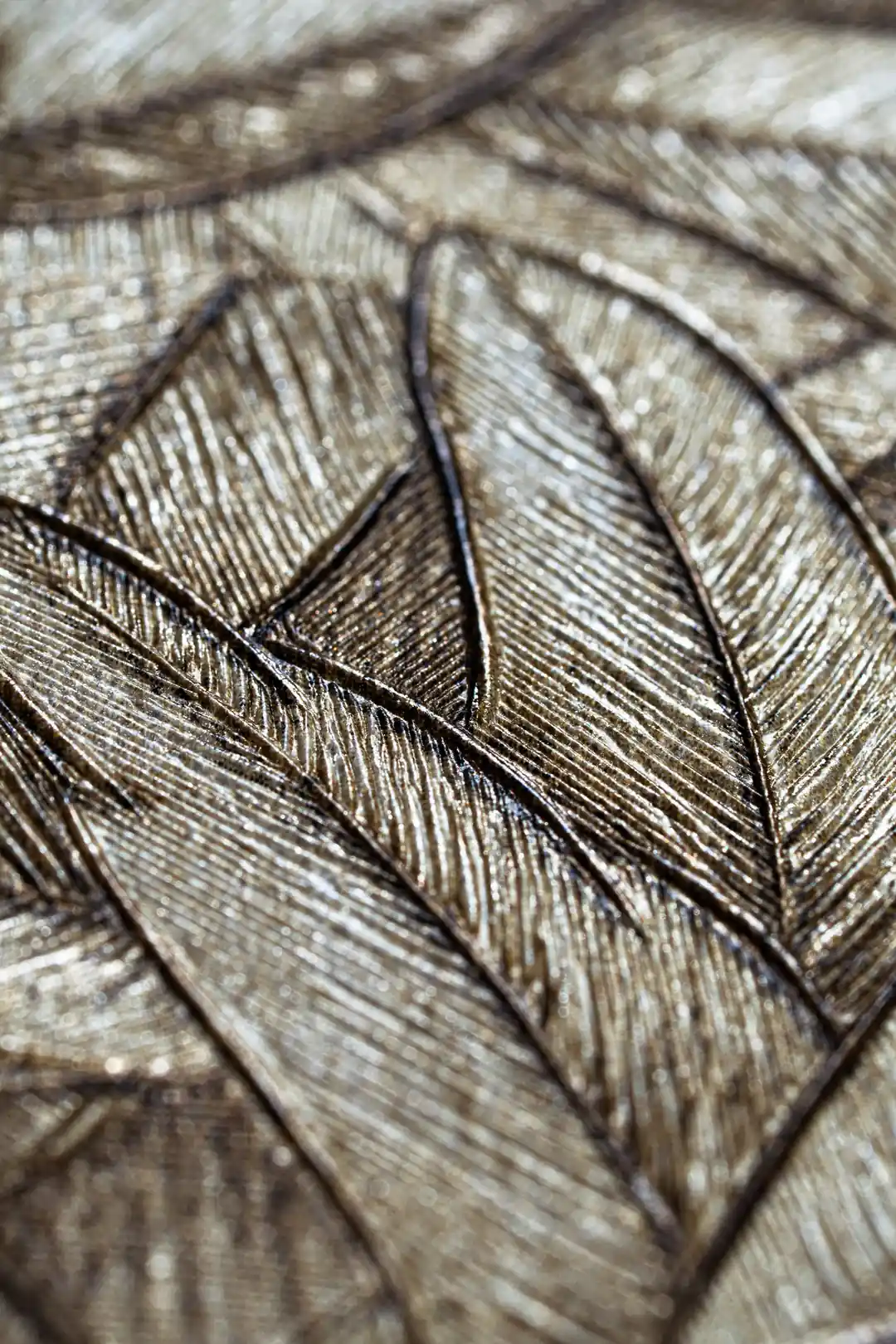 Extreme macro of overlapping bronze metallic leaf textures showing fine shimmer detail and veining