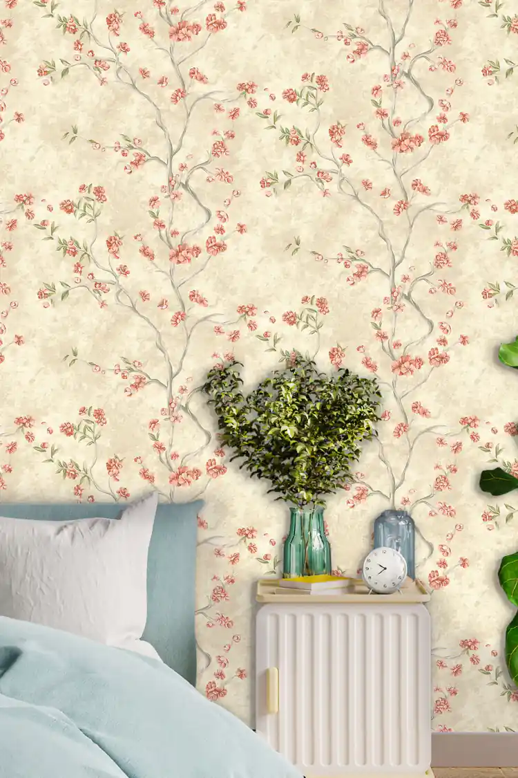 Bedroom scene with ivory blossom wallpaper featuring pink flowers behind a bed with blue bedding