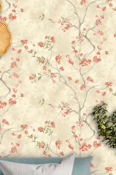 Close-up of pink cherry blossom branches scattered across an ivory wallpaper with a golden decorative piece on the wall